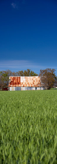 Blue sky over green fields and tin shed